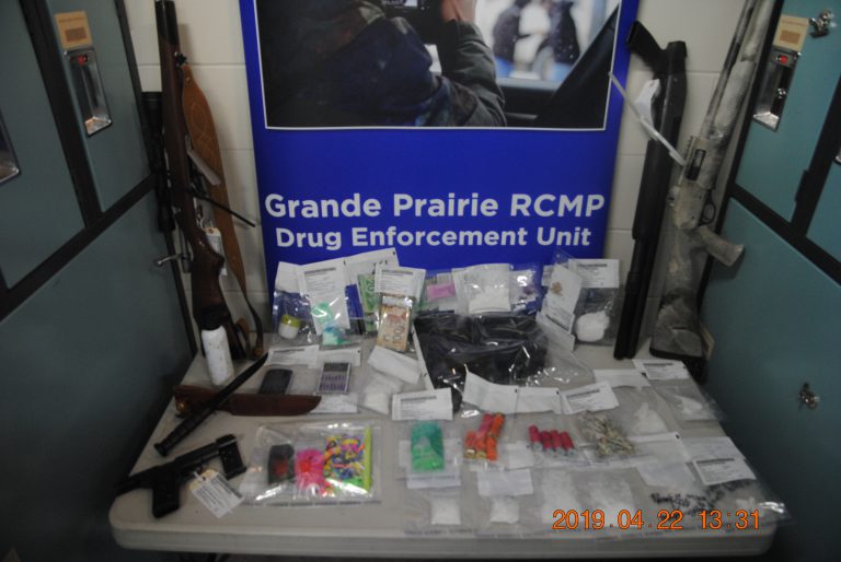 Four charged after RCMP seizes drugs, guns and money from residence