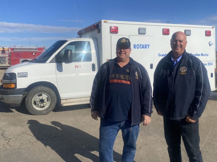 Project co-leaders Norm Lafleur (L) and Mark Morcette (R) in front of an ambulance donation (Ethan Montague, MyGPNow staff)